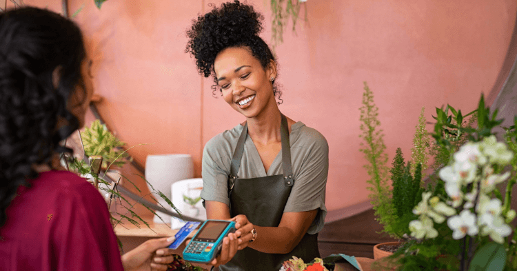 Woman handing a customer a payment machine