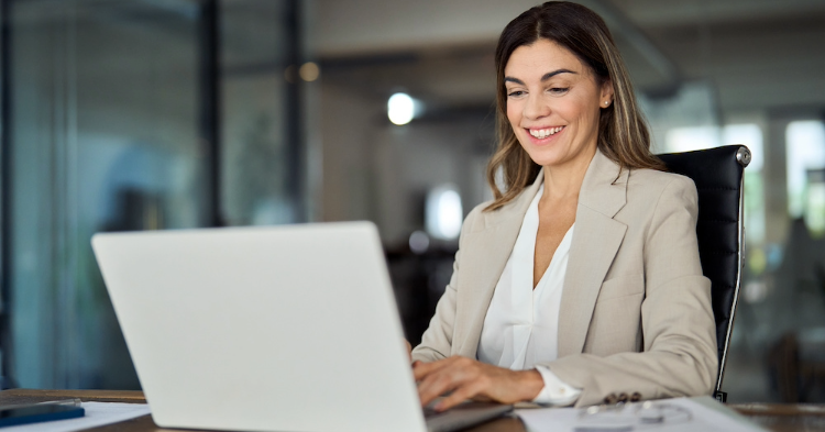 Business woman smiling at her laptop.