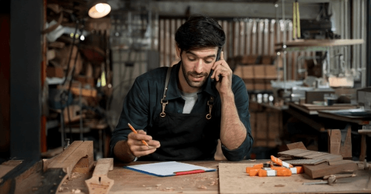 Small business owner at his work bench on the phone
