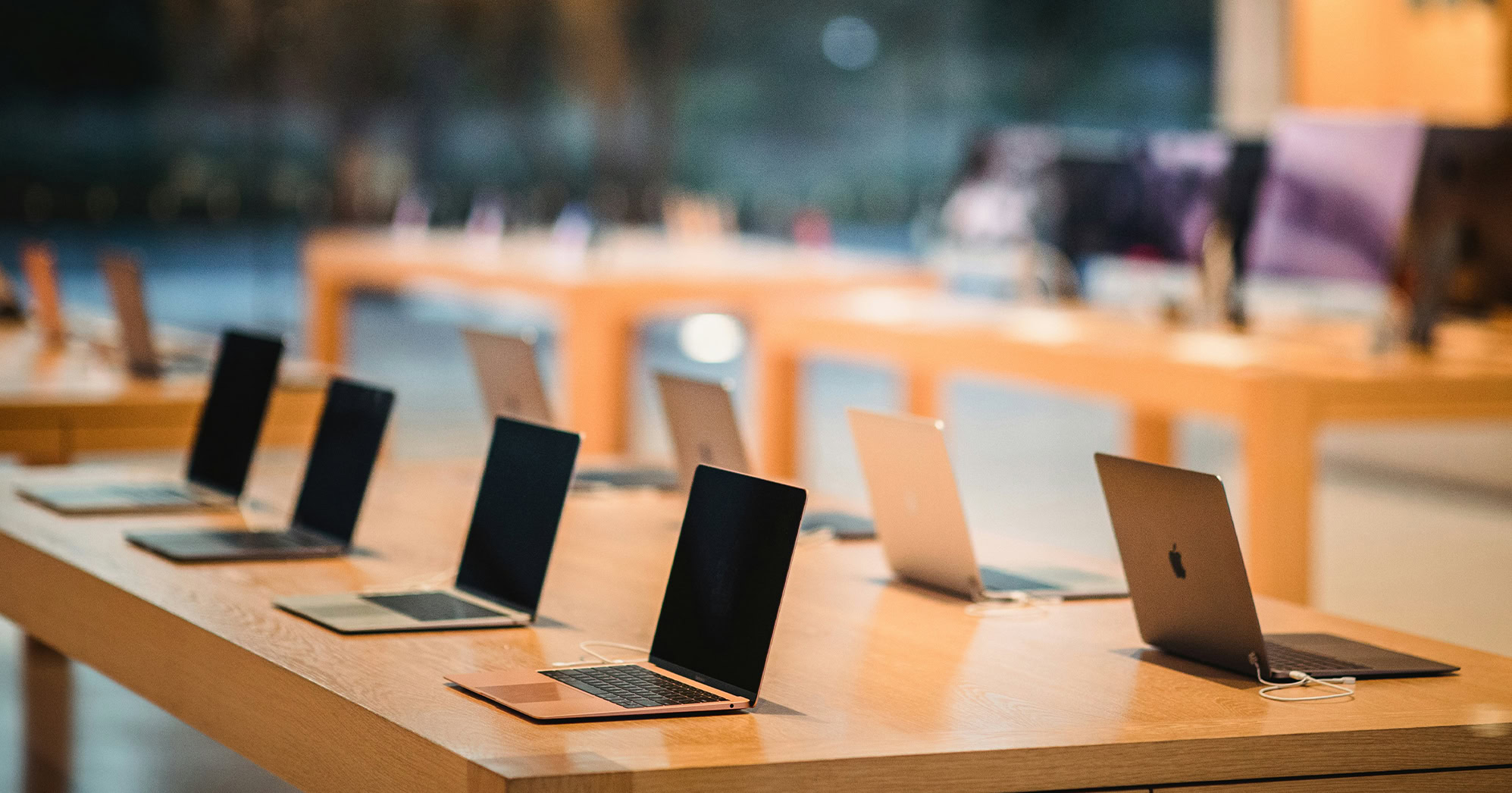 A photo with a table of open laptops.